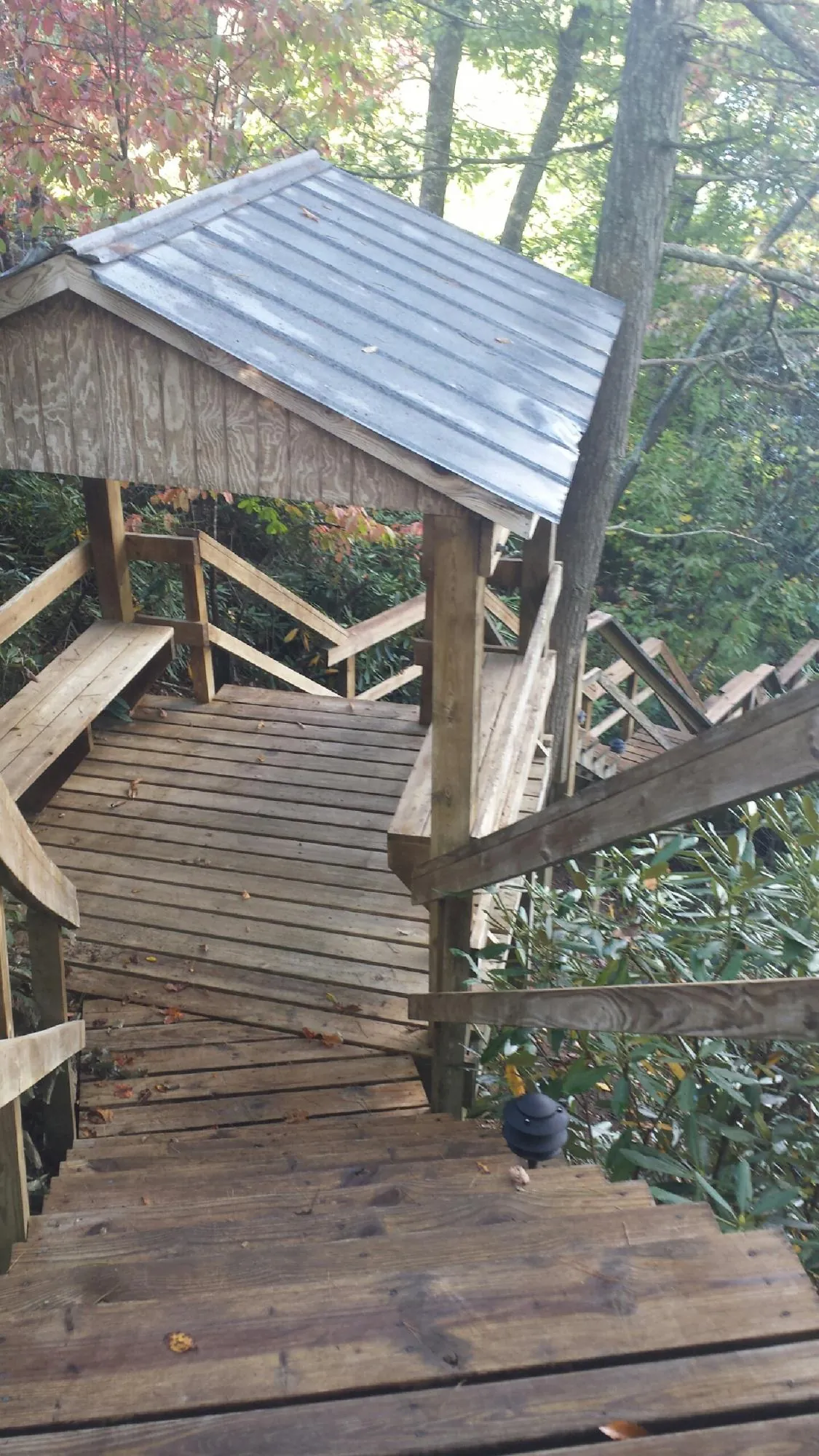 Metal roofed shelter over wooden steps on a wooded walkway — Skylight Repair & Installation work by our crew in Dover Plains